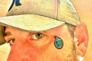 face of corey lee sargent dba green miyagi with earth teardrop brand logo face tattoo